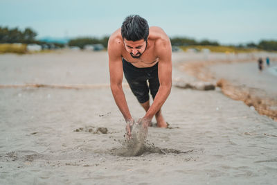 Shirtless exercising man on beach
