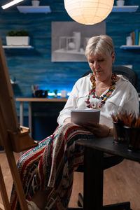 Senior woman writing in notebook at home