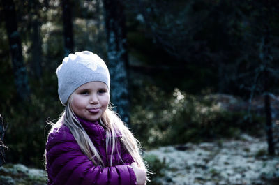 Portrait of smiling young woman against trees