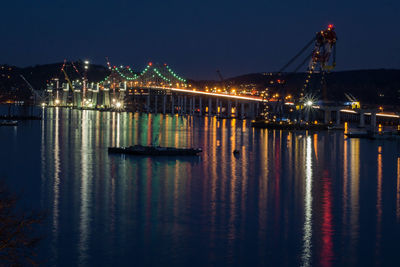 Illuminated tappan zee bridge over river at night