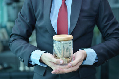 Midsection of businessman with currency