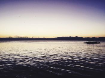 Scenic view of lake against clear sky during sunset