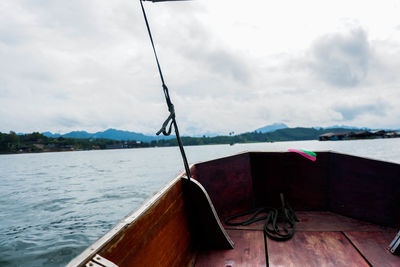 Sailboat moored on lake against sky