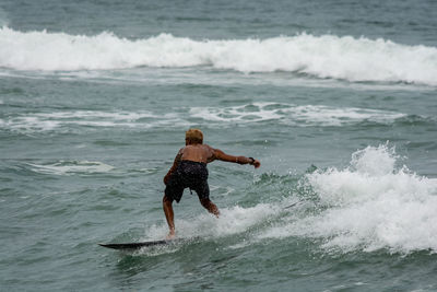 Full length of man splashing water in sea