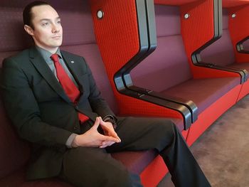 Mid adult man looking away while sitting on chair