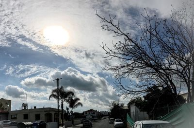 Cars on road against cloudy sky