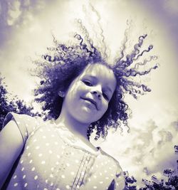 Portrait of young woman against sky