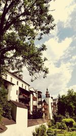 Low angle view of trees and buildings against sky