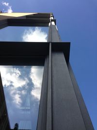 Low angle view of modern building against cloudy sky