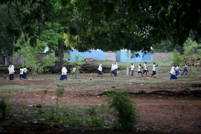 Group of people on field against trees