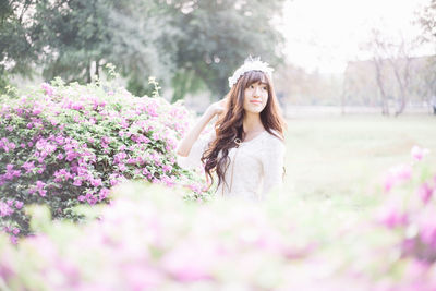 Woman standing by blooming flowers in park