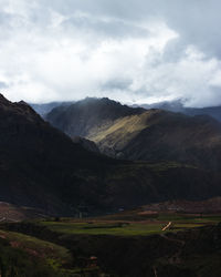 Scenic view of mountains against cloudy sky