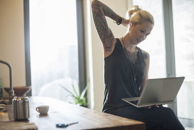 Midsection of woman using smart phone on table