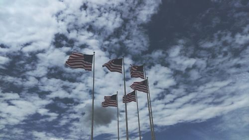 Low angle view of american flags against sky