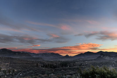 Scenic view of mountains against dramatic sky during sunset