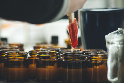 Close-up of hand holding salve over bottle