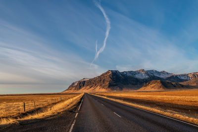 Empty road along countryside landscape