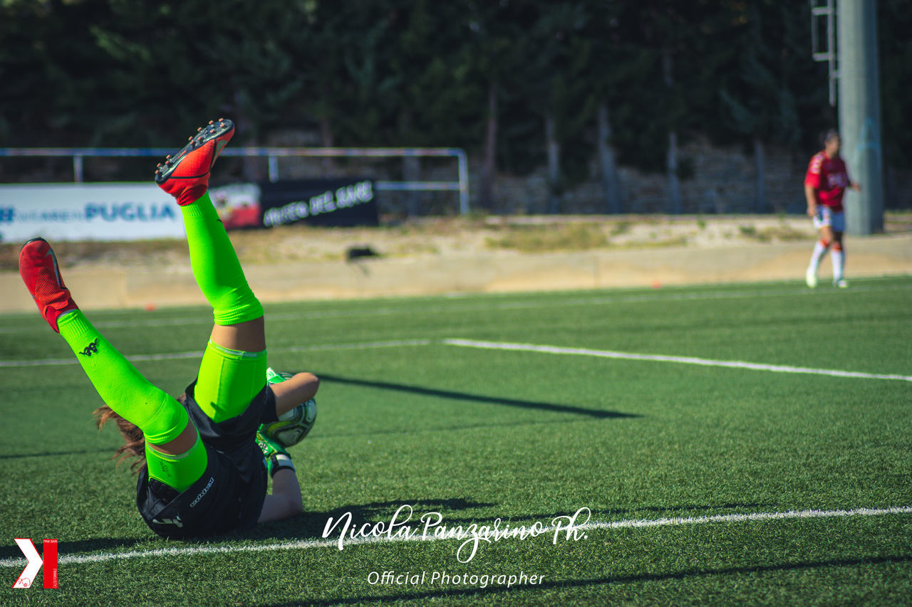 FULL LENGTH OF MAN ON FIELD AGAINST SOCCER BALL ON GRASS