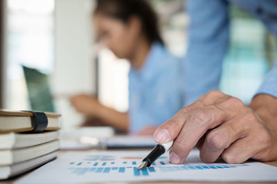 Cropped image of businessman working on graph at office