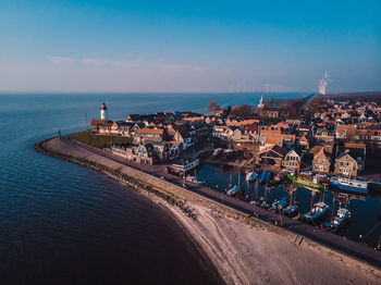 Aerial view of cityscape by sea against sky, lighthouse urk netherlands sunset