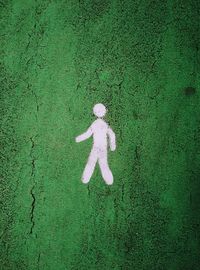 Man silhouette painted on a green textured surface