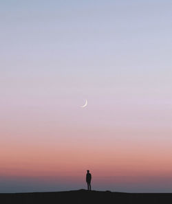 Low angle view of silhouette man standing against clear sky during sunset