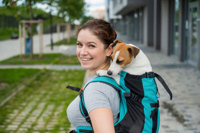 Portrait of young woman with dog on street