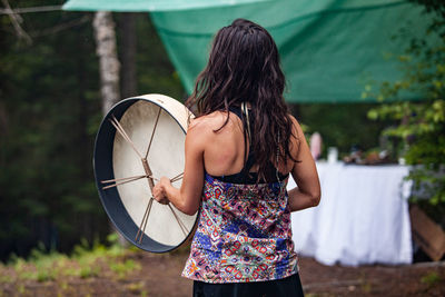 Rear view of woman standing with umbrella