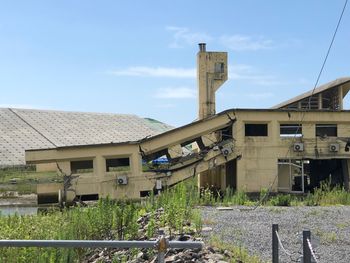 Exterior of old building in field against sky