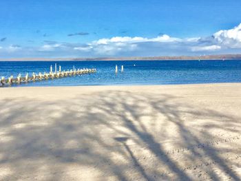 Scenic view of beach against blue sky