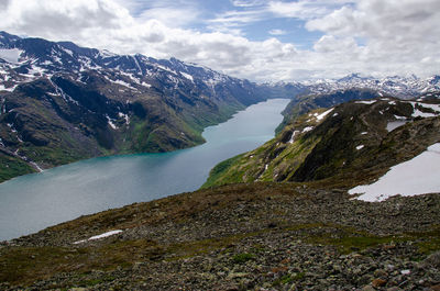 Scenic view of lake by mountains against sky