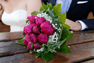 Close-up of person holding bouquet of red rose