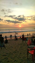 People at beach during sunset