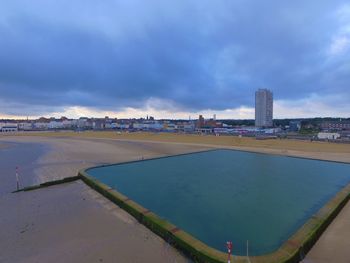 View of swimming pool in city against sky