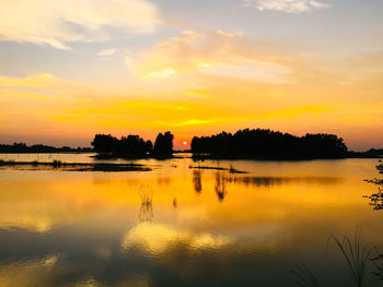 Scenic view of lake against orange sky