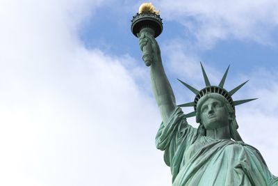 Low angle view of historic statue of liberty against sky