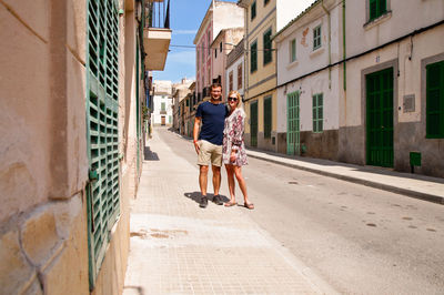 People walking on road amidst buildings in city