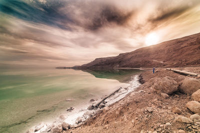 Scenic view of sea against cloudy sky during sunset