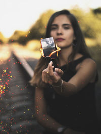 Portrait of woman burning photograph