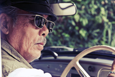 Side view of man wearing sunglasses in car 