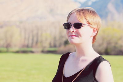 Portrait of young woman wearing sunglasses against sky