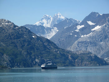 Scenic view of sea by mountains against sky