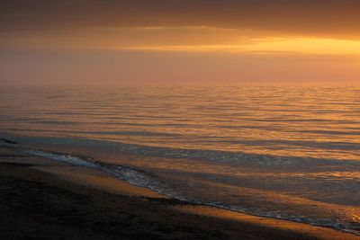 Scenic view of sea against orange sky