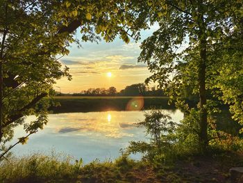 Scenic view of lake against sky during sunset