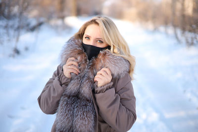 Portrait of woman wearing mask and warm clothing during winter