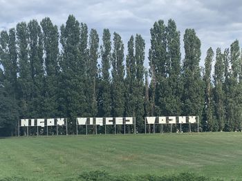 Scenic view of trees on field against sky