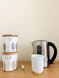 Coffee cup on table against wall