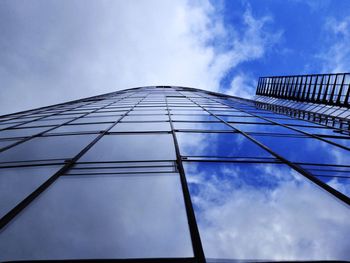 Low angle view of modern building against cloudy sky