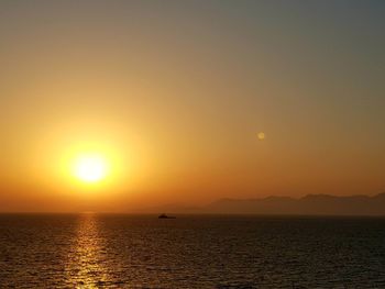 Scenic view of sea against orange sky