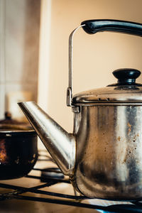 Close-up of kettle heating on burner in kitchen at home